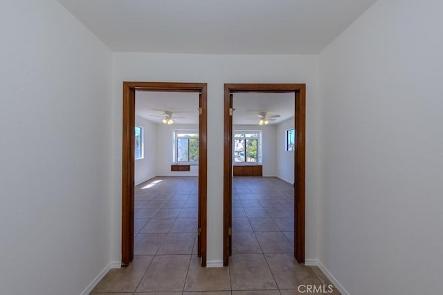 hall with light tile patterned floors and baseboards