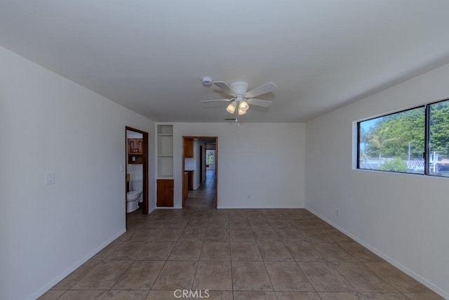 unfurnished room with ceiling fan, baseboards, and light tile patterned floors