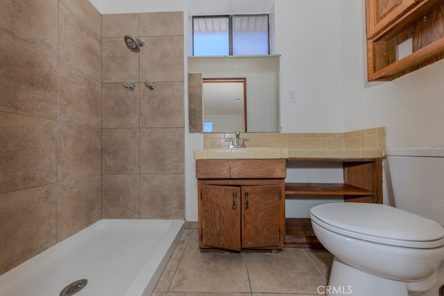 bathroom with tiled shower, toilet, vanity, tile patterned floors, and decorative backsplash