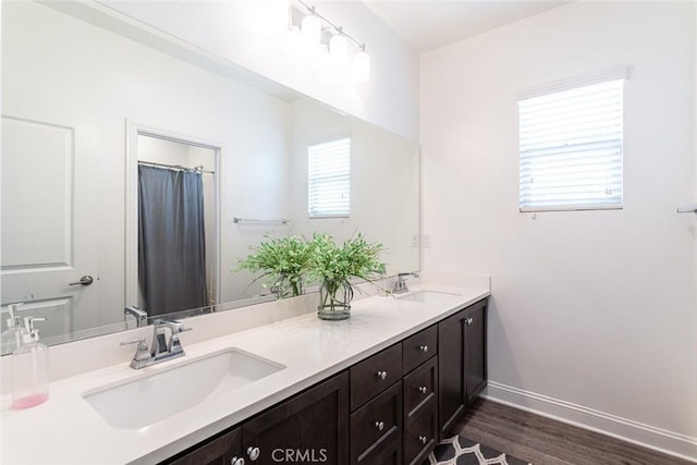 24449 Payton Dr, Lake Elsinore, CA 92532 - bathroom featuring wood finished floors, double vanity, and baseboards