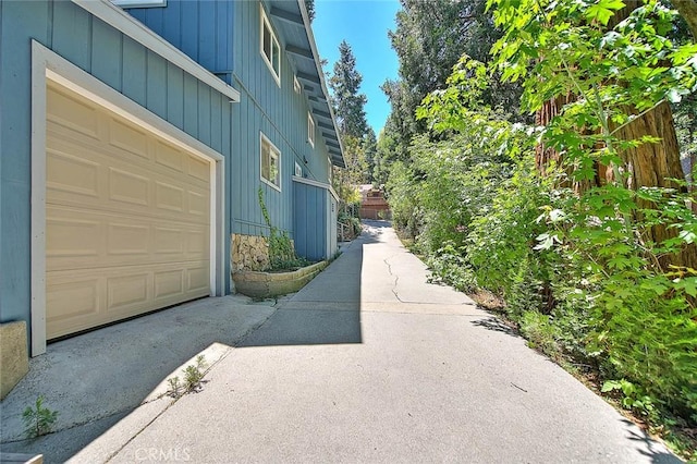 771 Woodland Rd, Crestline, CA 92325 - view of home's exterior featuring stone siding, a garage, and driveway