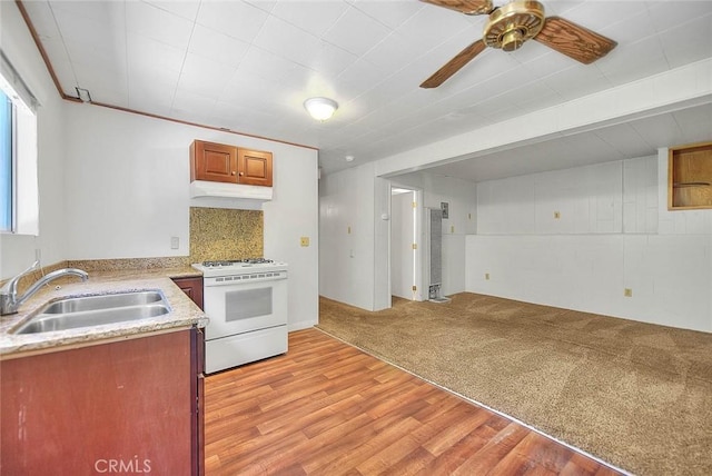 771 Woodland Rd, Crestline, CA 92325 - kitchen with white range with gas stovetop, a sink, under cabinet range hood, ceiling fan, and light wood-type flooring