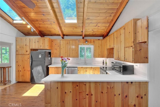 771 Woodland Rd, Crestline, CA 92325 - kitchen with black appliances, a skylight, a peninsula, light wood-style floors, and light countertops