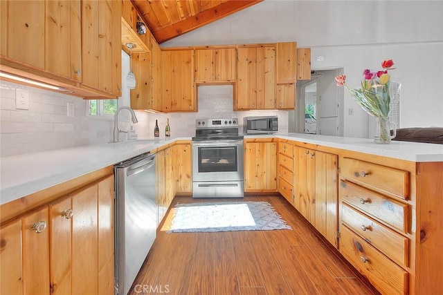 771 Woodland Rd, Crestline, CA 92325 - kitchen featuring stainless steel appliances, a peninsula, wood finished floors, lofted ceiling, and a sink