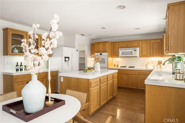 40 Calais, Irvine, CA 92602 - kitchen featuring white appliances, a sink, light wood-type flooring, a kitchen island, and glass insert cabinets
