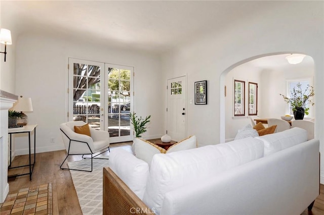 94 E Highland Ave, Sierra Madre, CA 91024 - living room featuring arched walkways, light wood finished floors, and baseboards
