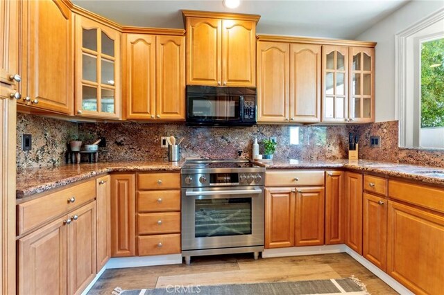 94 E Highland Ave, Sierra Madre, CA 91024 - kitchen with black microwave, high end stainless steel range oven, light stone counters, and glass insert cabinets