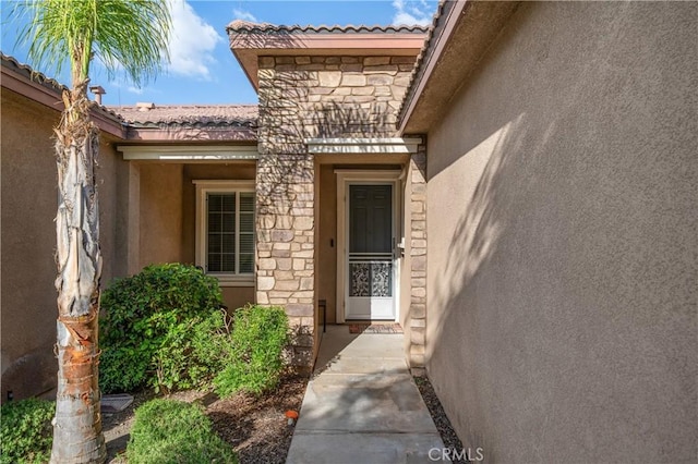 40991 Bankhall St, Lake Elsinore, CA 92532 - view of exterior entry featuring stucco siding, a tile roof, and stone siding