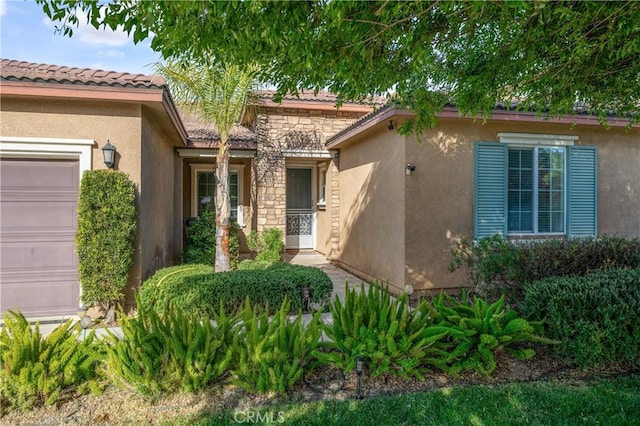 40991 Bankhall St, Lake Elsinore, CA 92532 - doorway to property with stucco siding, a garage, and a tiled roof