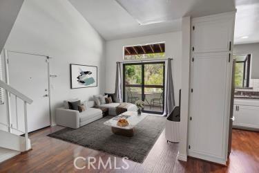 27929 Tyler Ln Unit 744, Canyon Country, CA 91387 - living room with dark wood finished floors, stairway, and high vaulted ceiling