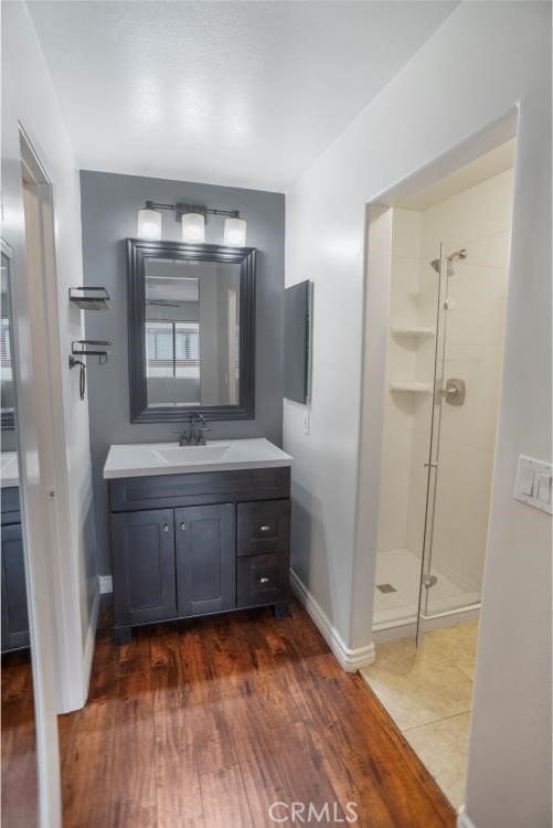 27929 Tyler Ln Unit 744, Canyon Country, CA 91387 - bathroom featuring baseboards, a shower stall, vanity, and wood finished floors