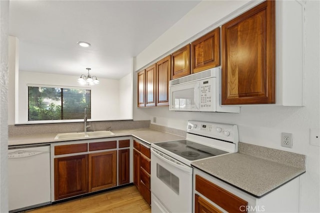 2912 Pennyroyal Dr, Chico, CA 95928 - kitchen with white appliances, a sink, light wood-type flooring, brown cabinets, and a chandelier