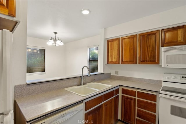 2912 Pennyroyal Dr, Chico, CA 95928 - kitchen featuring white appliances, a sink, brown cabinetry, a chandelier, and pendant lighting