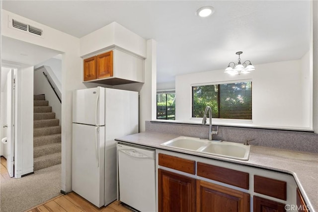 2912 Pennyroyal Dr, Chico, CA 95928 - kitchen featuring white appliances, a sink, light wood finished floors, a chandelier, and brown cabinets