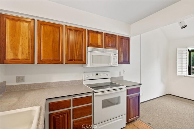 2912 Pennyroyal Dr, Chico, CA 95928 - kitchen with white appliances, brown cabinetry, and a sink