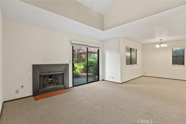 2912 Pennyroyal Dr, Chico, CA 95928 - unfurnished living room featuring carpet floors, a chandelier, a fireplace with flush hearth, and baseboards
