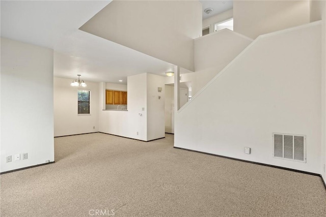 2912 Pennyroyal Dr, Chico, CA 95928 - unfurnished living room with light colored carpet, baseboards, and a chandelier
