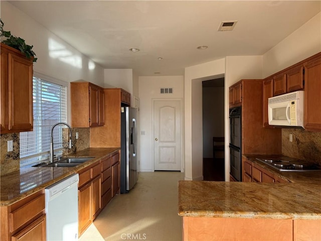 5486 Alexandrine Ct, Oceanside, CA 92057 - kitchen with white appliances, a sink, stone counters, brown cabinetry, and backsplash