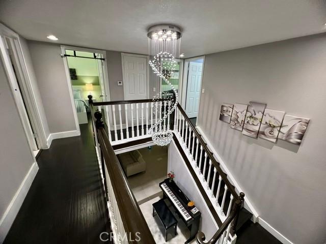 2163 N Justin Ave N, Simi Valley, CA 93065 - staircase with baseboards, a chandelier, and wood finished floors