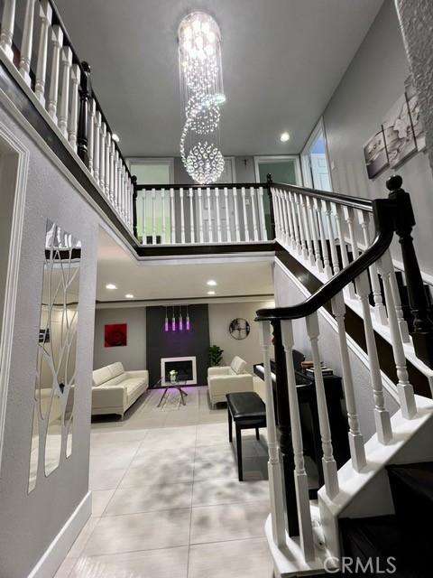 2163 N Justin Ave N, Simi Valley, CA 93065 - staircase with a chandelier, a high ceiling, and tile patterned floors