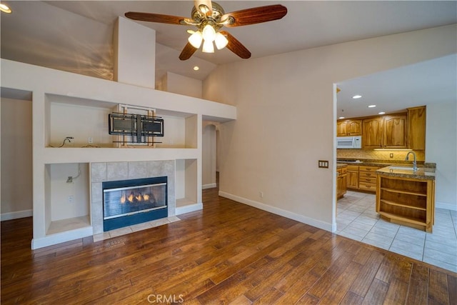 635 Shelter Ridge Pl, Nipomo, CA 93444 - unfurnished living room with light wood-type flooring, a ceiling fan, lofted ceiling, a tile fireplace, and recessed lighting