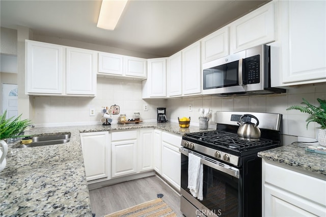 1963 Turrill Ave, San Bernardino, CA 92411 - kitchen featuring stainless steel appliances, a sink, white cabinets, and decorative backsplash
