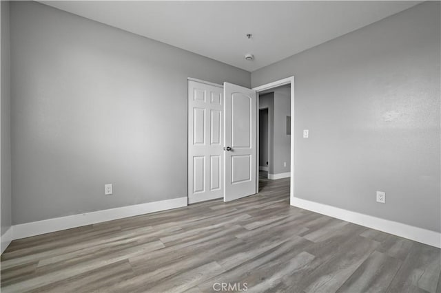 202 E 116th St, Los Angeles, CA 90061 - unfurnished bedroom featuring baseboards, wood finished floors, and a closet