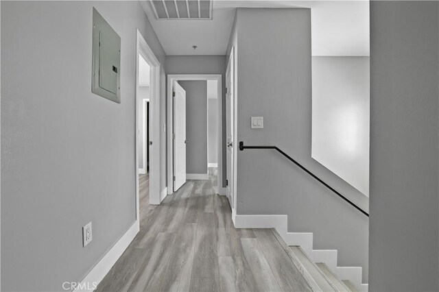 202 E 116th St, Los Angeles, CA 90061 - corridor with electric panel, an upstairs landing, wood finished floors, and baseboards