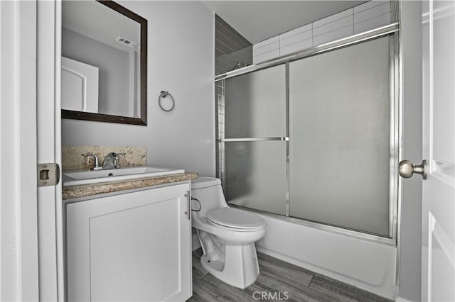 202 E 116th St, Los Angeles, CA 90061 - bathroom featuring toilet, enclosed tub / shower combo, vanity, and wood finished floors