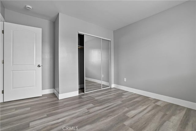 202 E 116th St, Los Angeles, CA 90061 - unfurnished bedroom with wood finished floors, a closet, and baseboards