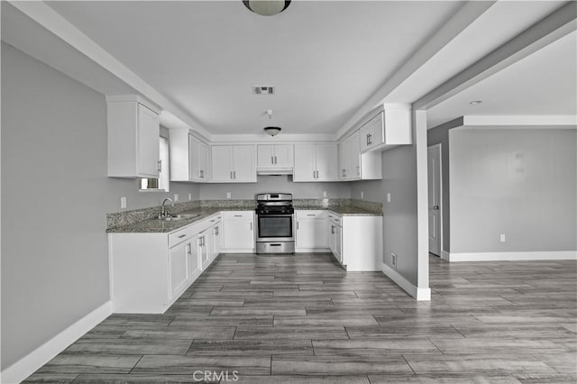 202 E 116th St, Los Angeles, CA 90061 - kitchen featuring stainless steel gas stove, a sink, dark stone countertops, baseboards, and under cabinet range hood