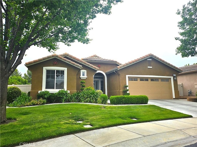 197 Potter Crk, Beaumont, CA 92223 - mediterranean / spanish home featuring an attached garage, stucco siding, a tiled roof, and driveway