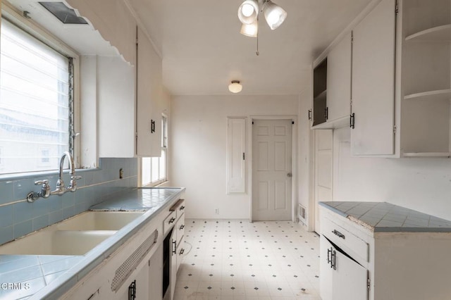 8528 Palma Vista St, San Gabriel, CA 91775 - kitchen featuring light flooring, a sink, tasteful backsplash, tile counters, and white cabinets