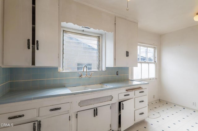 8528 Palma Vista St, San Gabriel, CA 91775 - kitchen featuring a sink, decorative backsplash, white cabinetry, light flooring, and tile counters