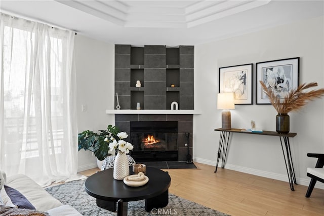 2500 Abbot Kinney Blvd Unit 9, Venice, CA 90291 - living room featuring a tray ceiling, a tiled fireplace, wood finished floors, and baseboards