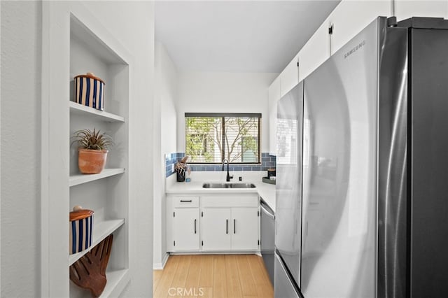 2500 Abbot Kinney Blvd Unit 9, Venice, CA 90291 - kitchen with appliances with stainless steel finishes, a sink, light wood finished floors, and white cabinetry