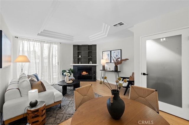 2500 Abbot Kinney Blvd Unit 9, Venice, CA 90291 - living area featuring a raised ceiling, light wood-style flooring, a tile fireplace, built in shelves, and baseboards