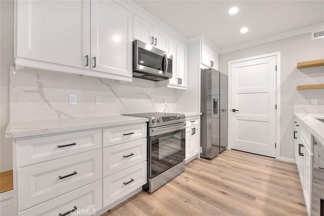 2040 Las Colinas Cir Unit 104, Corona, CA 92879 - kitchen with appliances with stainless steel finishes, open shelves, white cabinets, light wood-style floors, and crown molding