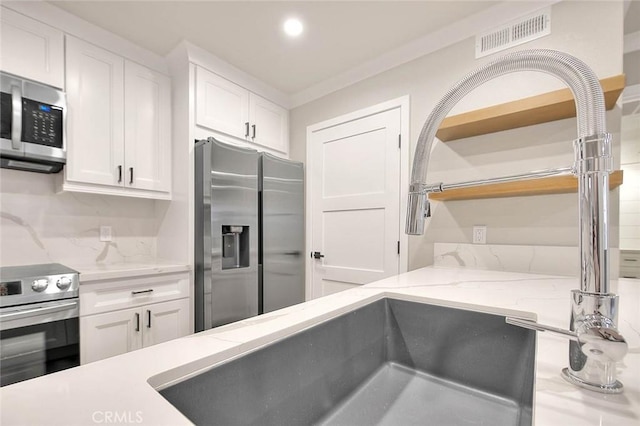2040 Las Colinas Cir Unit 104, Corona, CA 92879 - kitchen with appliances with stainless steel finishes, open shelves, white cabinetry, backsplash, and recessed lighting