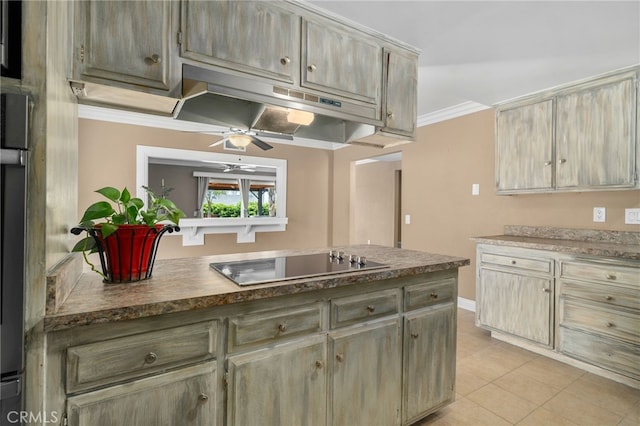 8631 Holly St, Rancho Cucamonga, CA 91701 - kitchen with black electric stovetop, under cabinet range hood, ceiling fan, light tile patterned floors, and ornamental molding