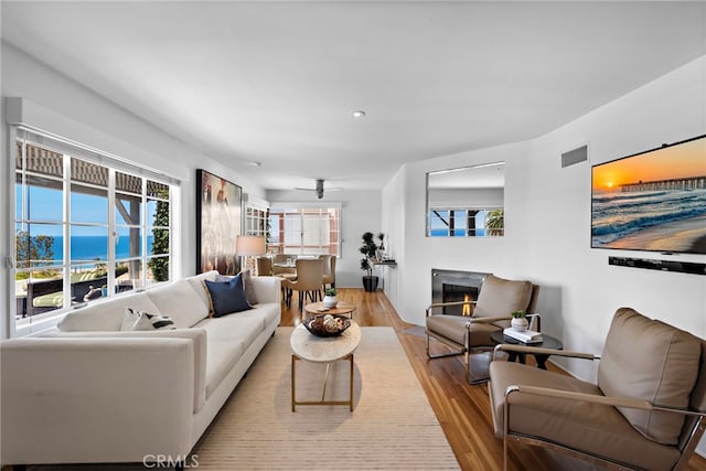 2142 Ruby Pl, Laguna Beach, CA 92651 - living area with light wood-style floors, plenty of natural light, a lit fireplace, and recessed lighting
