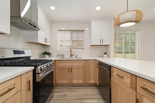 1988 Thornton St, Riverside, CA 92507 - kitchen with stainless steel gas stove, a sink, wall chimney exhaust hood, dishwashing machine, and light wood-style floors