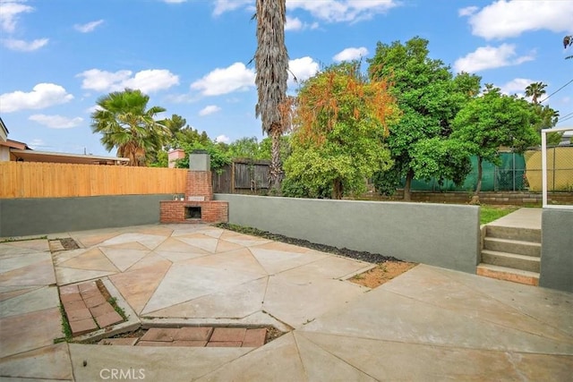 1988 Thornton St, Riverside, CA 92507 - view of patio featuring an outdoor brick fireplace and a fenced backyard