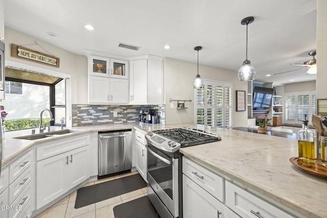 825 Murdoch Ln, Ventura, CA 93003 - kitchen featuring appliances with stainless steel finishes, a sink, decorative backsplash, white cabinetry, and light tile patterned floors