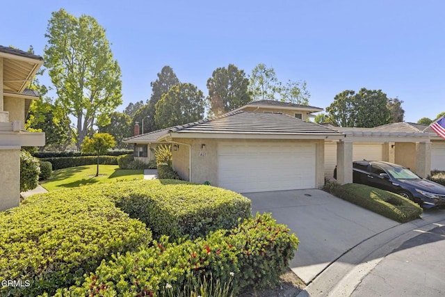 825 Murdoch Ln, Ventura, CA 93003 - view of front of house with an attached garage, driveway, a tiled roof, stucco siding, and a front yard