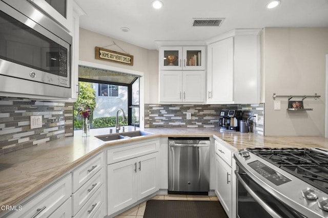 825 Murdoch Ln, Ventura, CA 93003 - kitchen with stainless steel appliances, a sink, decorative backsplash, white cabinetry, and recessed lighting