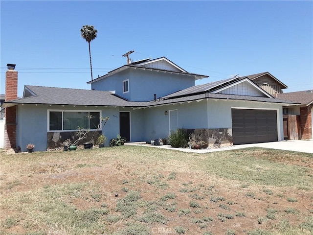 6473 Capistrano Way, Riverside, CA 92504 - view of front of home with a garage, solar panels, a front lawn, and concrete driveway