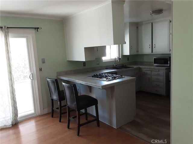 6473 Capistrano Way, Riverside, CA 92504 - kitchen featuring a sink, stainless steel appliances, ornamental molding, a peninsula, and tile counters