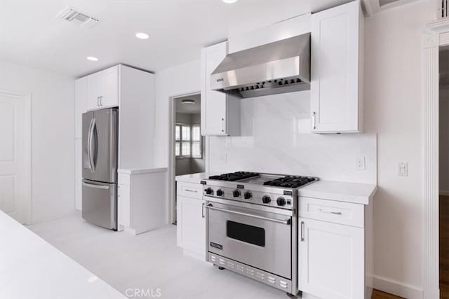 12535 Kling St, Studio City, CA 91604 - kitchen with appliances with stainless steel finishes, wall chimney range hood, light countertops, white cabinetry, and recessed lighting