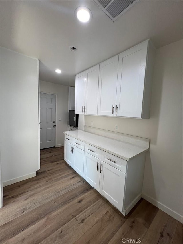 3065 Sastre Ave, El Monte, CA 91733 - kitchen with baseboards, wood finished floors, white cabinets, light countertops, and recessed lighting